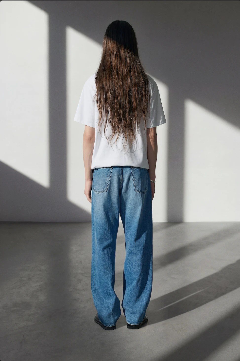 Peace Begins Within mid blue jeans and white t-shirt on model, back view